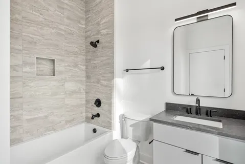 a bathroom with a granite countertop sink toilet and shower