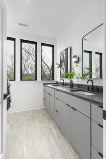 a spacious bathroom with double vanity and a large mirror