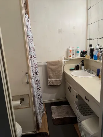 a bathroom with a sink and mirror with toilet