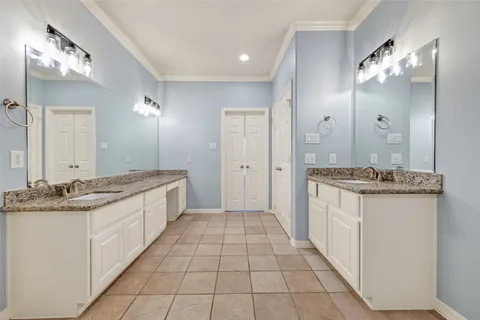 a large bathroom with a granite countertop double vanity sink a mirror and a shower