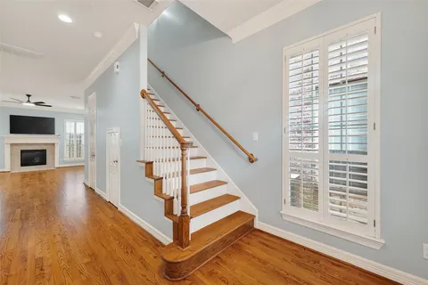 a view of a hallway with wooden floor and staircase