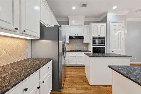 a kitchen with kitchen island granite countertop a stove a sink and a refrigerator