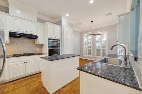 a kitchen with granite countertop a sink stove and cabinets