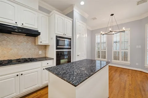 a kitchen with stainless steel appliances granite countertop a sink stove and cabinets