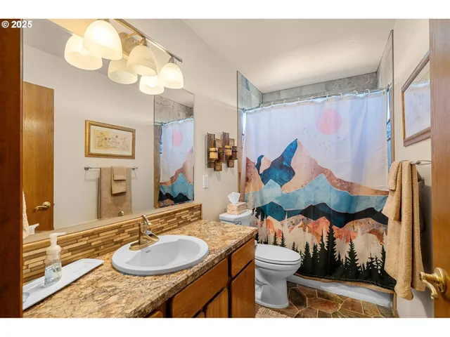 a bathroom with a sink vanity mirror and toilet