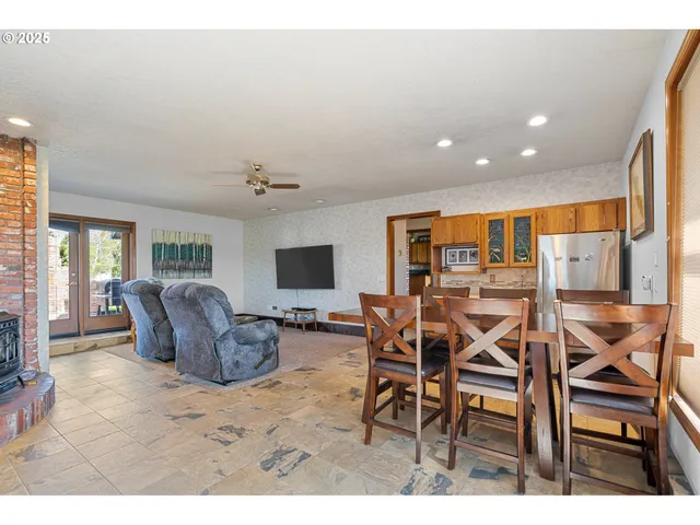a dining room with furniture a window and a flat screen tv