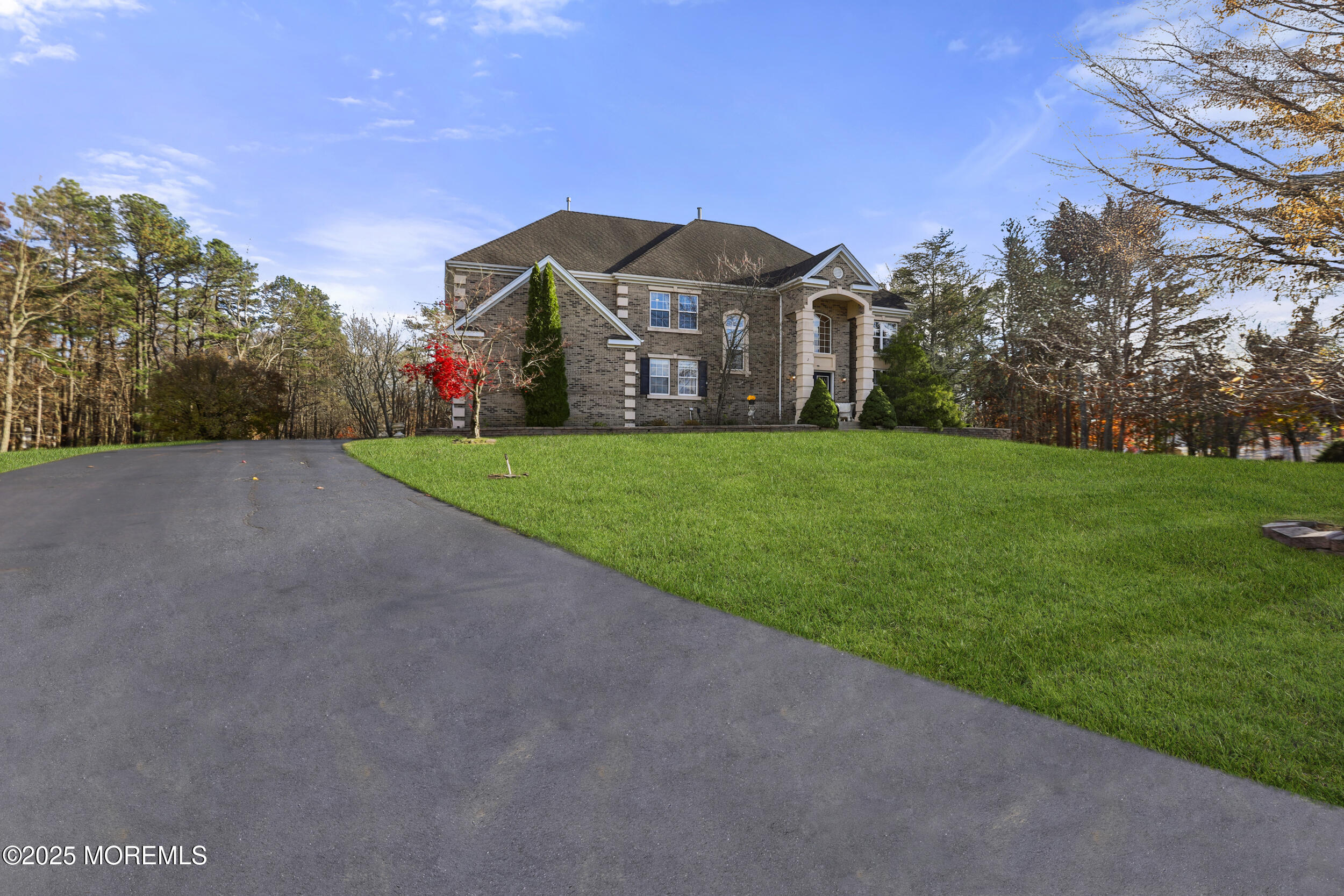 a view of a big house with a big yard and large trees