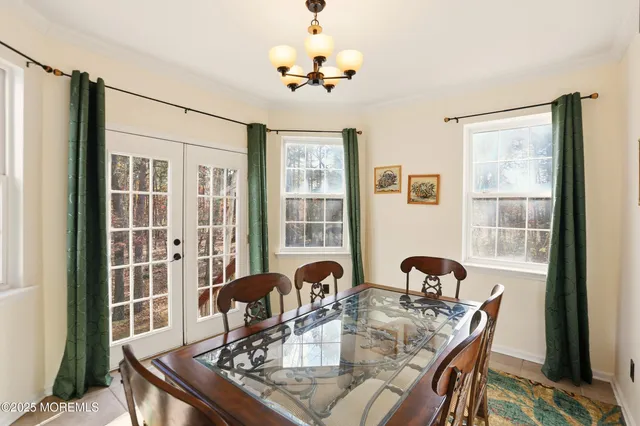 a view of a dining room with furniture a chandelier and wooden floor