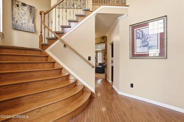 a view of staircase with wooden floor and white walls