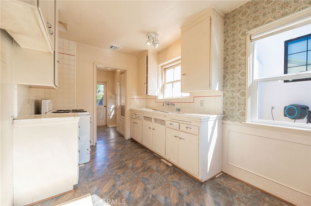 1425 Thompson Avenue Glendale, CA 91201 - Photo 26 of 44 a kitchen with granite countertop white cabinets and white appliances