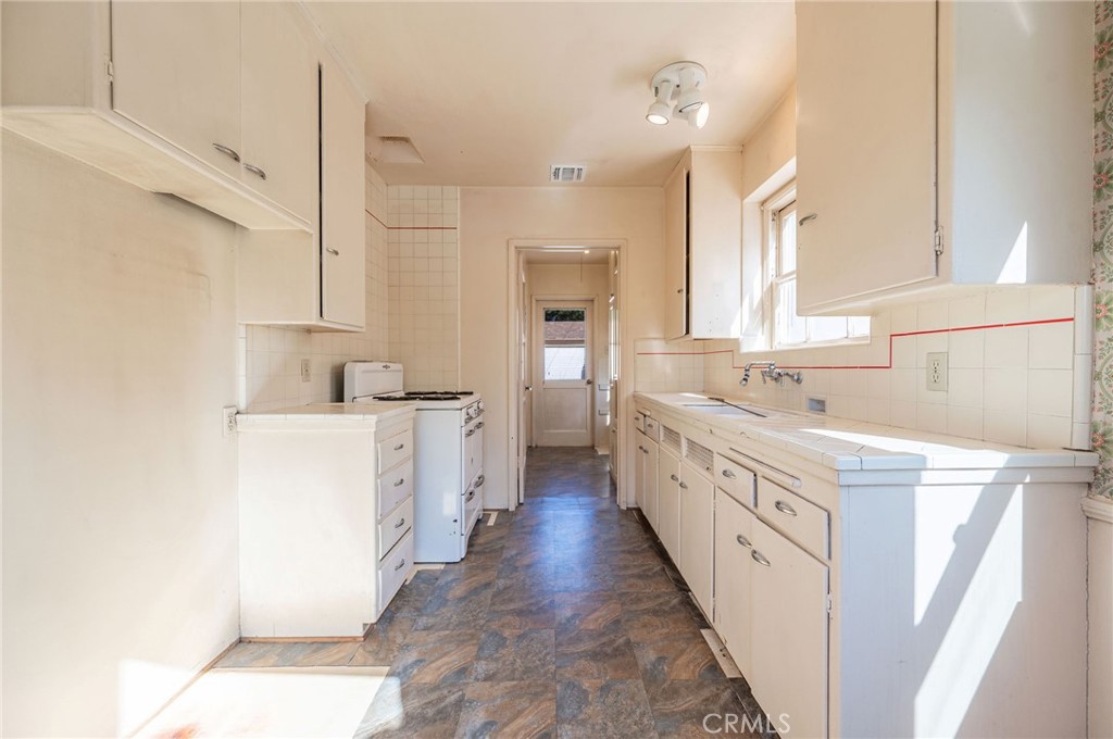 1425 Thompson Avenue Glendale, CA 91201 - Photo 27 of 44 a large white kitchen with cabinets a sink and a stove