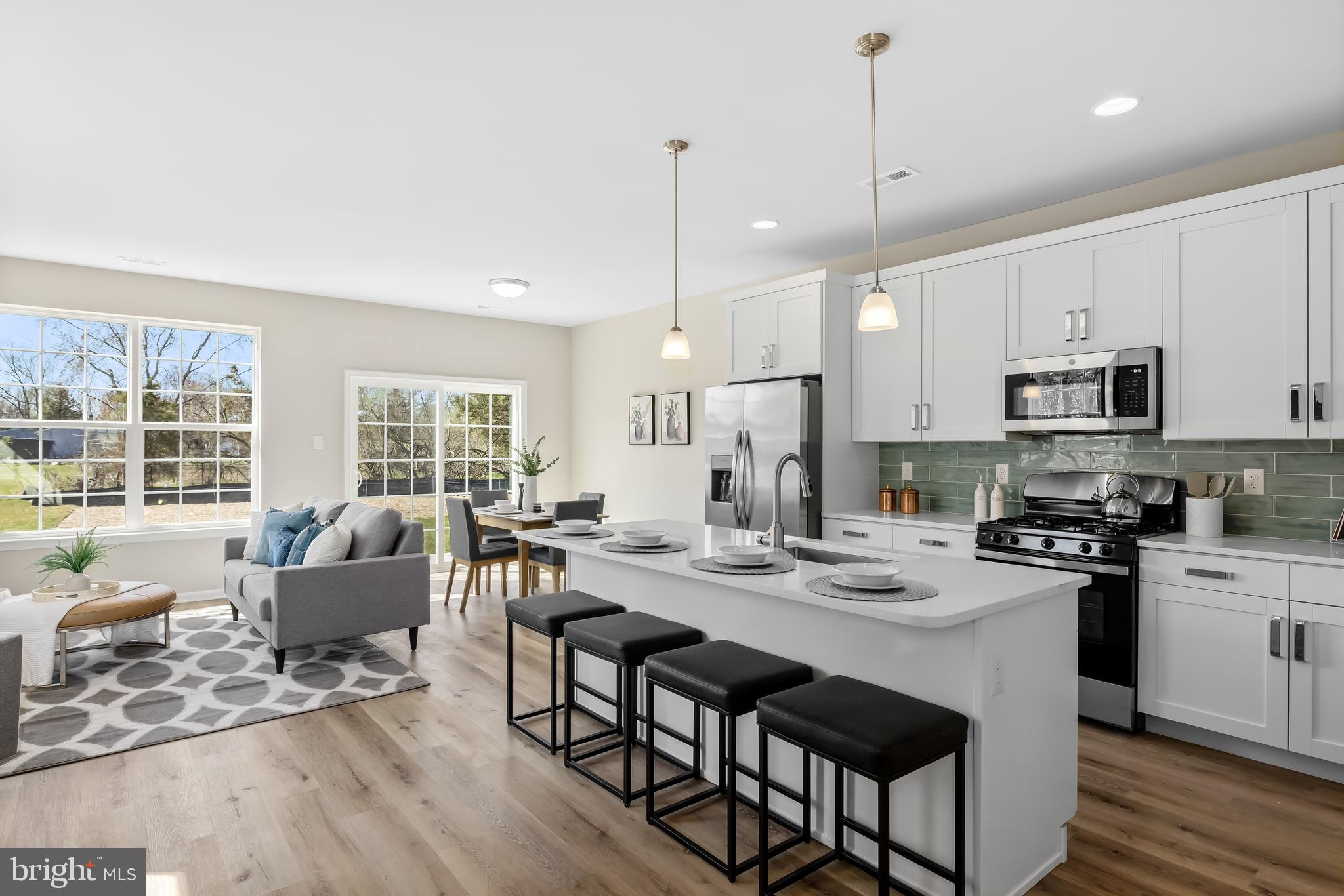 385 North Tuckahoe Road, Unit 992 Williamstown, NJ 08094 - Photo 4 of 21 a kitchen with stainless steel appliances granite countertop a stove a sink a microwave a dining table and chairs with wooden floor