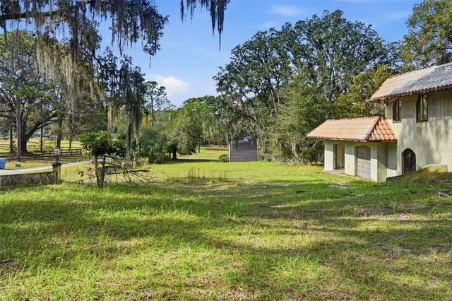 a backyard of a house with wooden floor and fence