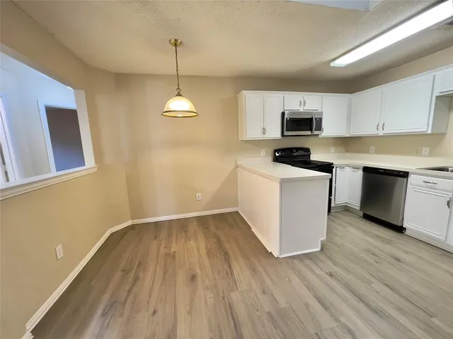 a kitchen with wooden floors and white appliances