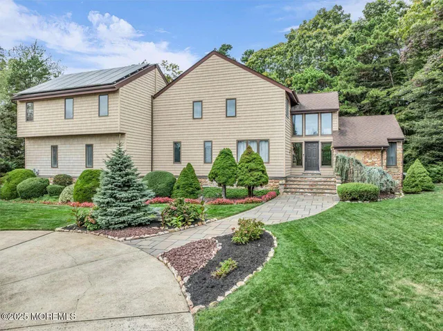 a view of a white house with a yard and plants