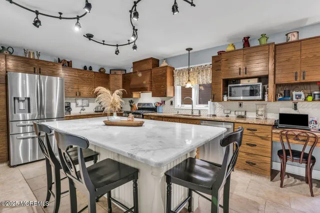 a kitchen with stainless steel appliances granite countertop a stove and a refrigerator