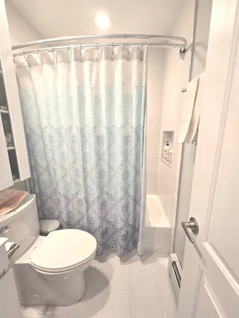 a bathroom with a toilet and a shower curtain