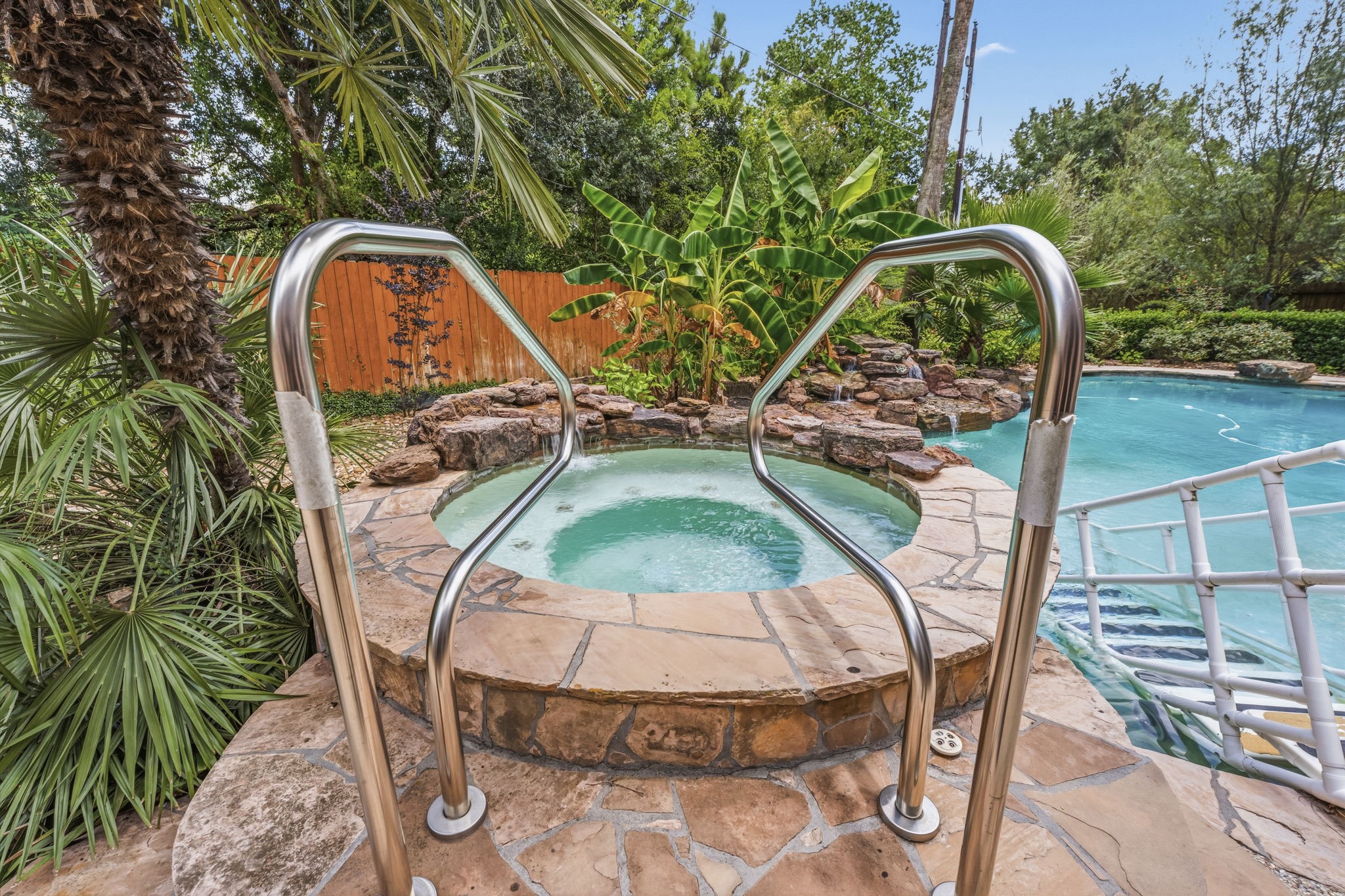 18503 Cabaniss Circle Spring, TX 77379 - Photo 34 of 49 The raised spa spills into the pool below. There is a staircase that allows easy access in and out of the pool for people of all ages.