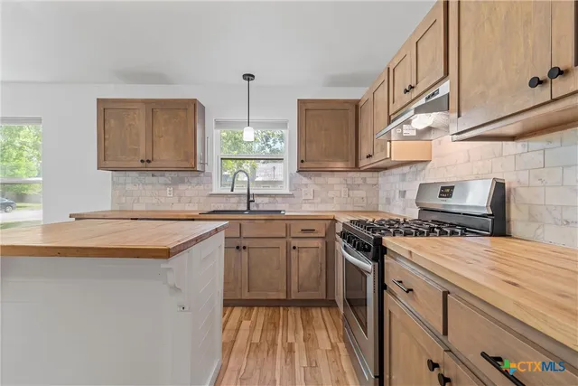 a kitchen with a sink stove and cabinets