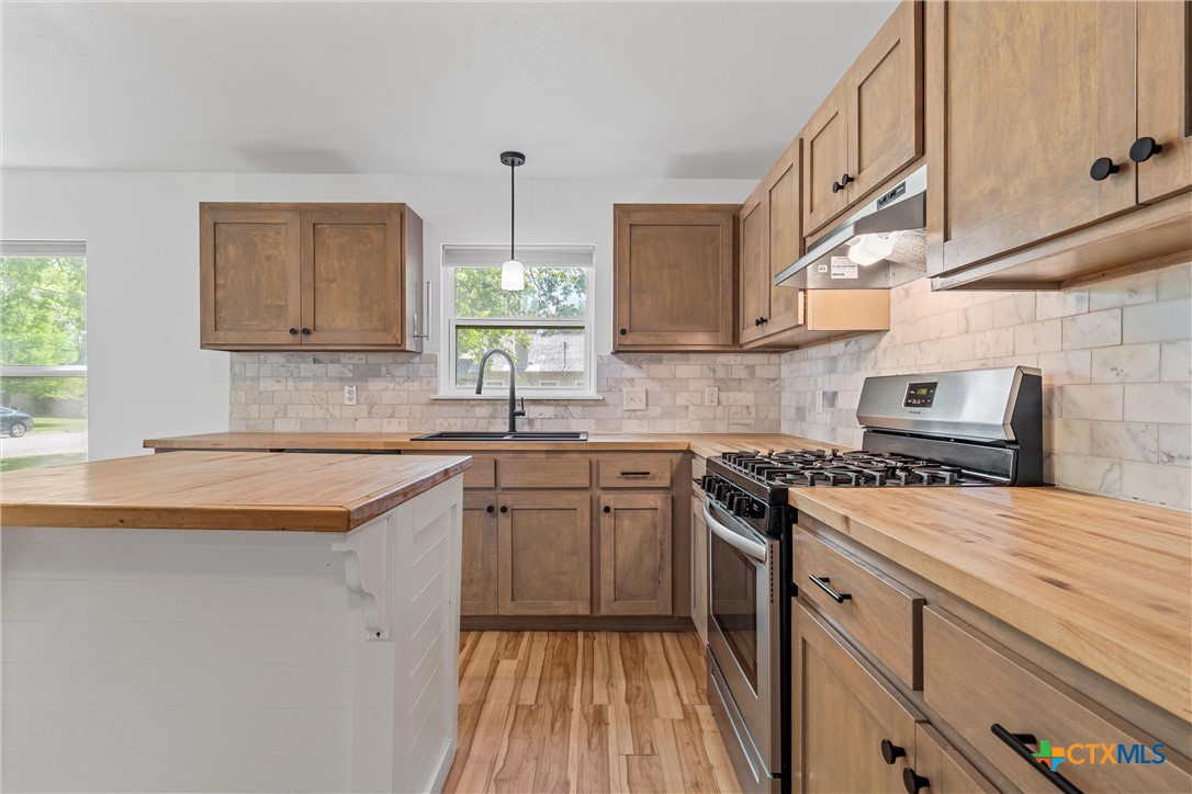 a kitchen with a sink stove and cabinets