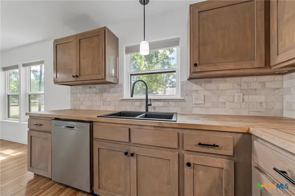 a kitchen with stainless steel appliances granite countertop a sink a cabinets and window