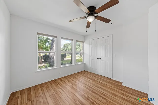 a view of room with wooden floor and ceiling fan
