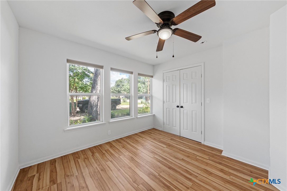 407 East 7th Street Cameron, TX 76520 - Photo 19 of 43 a view of an empty room with wooden floor and a window