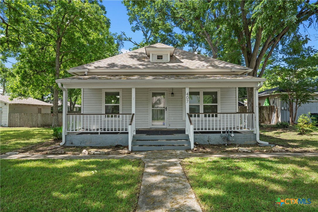 407 East 7th Street Cameron, TX 76520 - Photo 2 of 43 a front view of a house with a garden