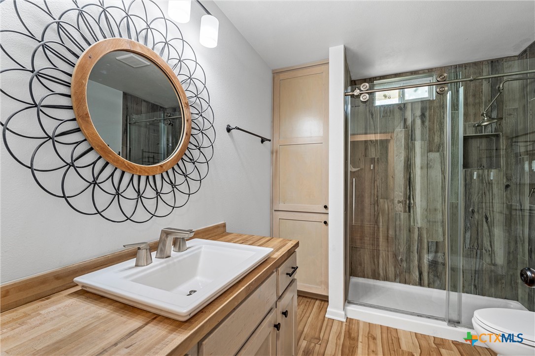 407 East 7th Street Cameron, TX 76520 - Photo 23 of 43 a bathroom with a sink a mirror and a shower