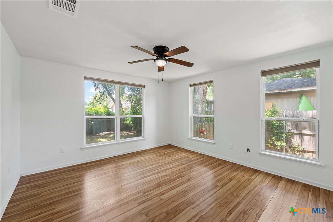 407 East 7th Street Cameron, TX 76520 - Photo 25 of 43 wooden floor in an empty room with a window
