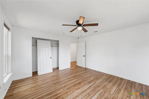 a view of room with wooden floor and ceiling fan