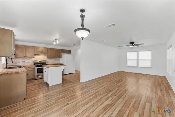 a view of a kitchen with sink and wooden floor