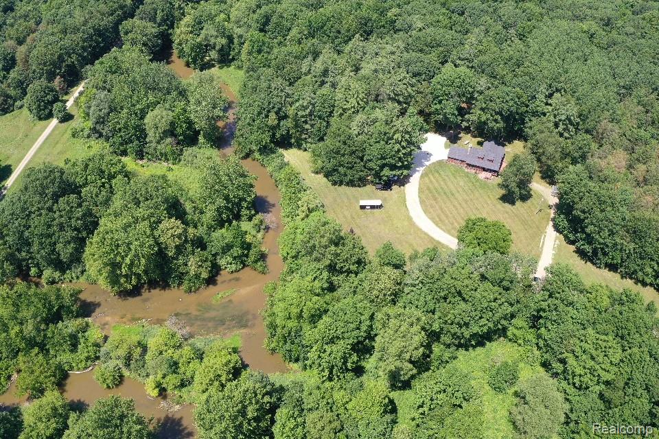 3656 Stanley Road Columbiaville, MI 48421 - Photo 52 of 65 Expansive wooded property featuring a meandering river, a residential structure, and a curved driveway
