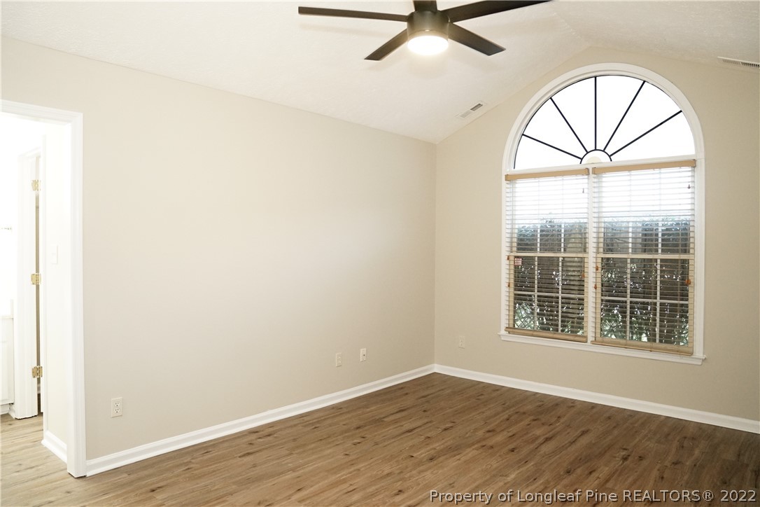 2940 Bakers Mill Road Fayetteville, NC 28306 - Photo 22 of 46 an empty room with wooden floor fan and windows