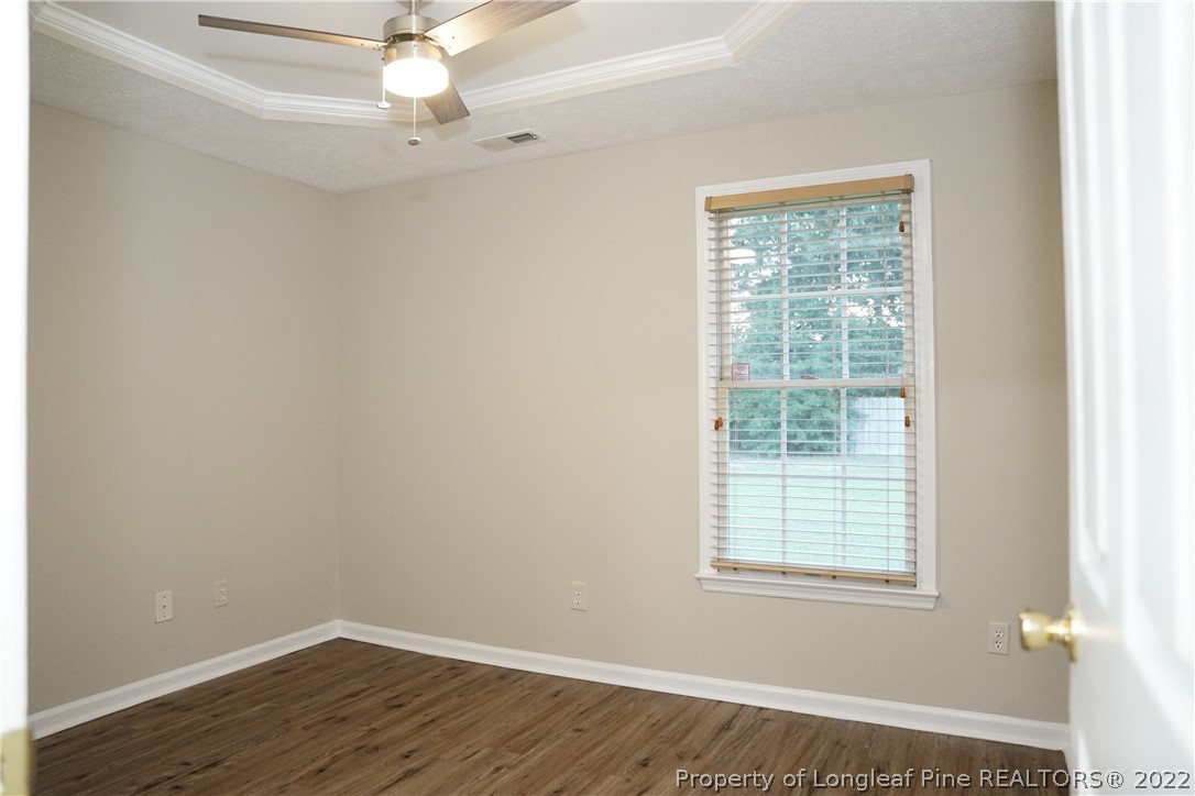 2940 Bakers Mill Road Fayetteville, NC 28306 - Photo 38 of 46 an empty room with wooden floor fan and windows