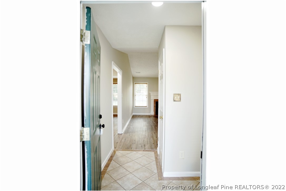 2940 Bakers Mill Road Fayetteville, NC 28306 - Photo 5 of 46 a view of a hallway with white walls and a painting