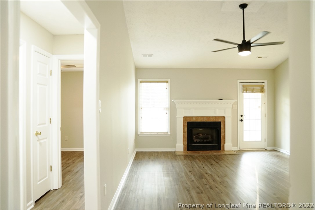 2940 Bakers Mill Road Fayetteville, NC 28306 - Photo 6 of 46 a view of an empty room with wooden floor fireplace and a window