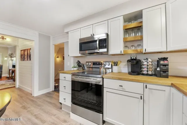 a kitchen with stainless steel appliances granite countertop a stove a sink and a microwave