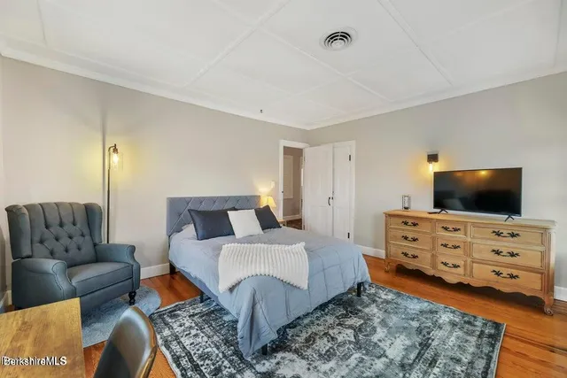 a bedroom with a bed and wooden floor