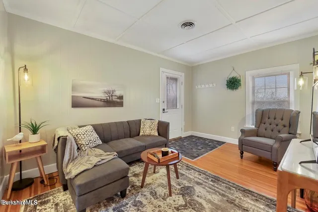 a living room with furniture a rug and a table