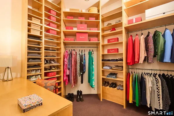 a view of walk in closet with clothes and shoes