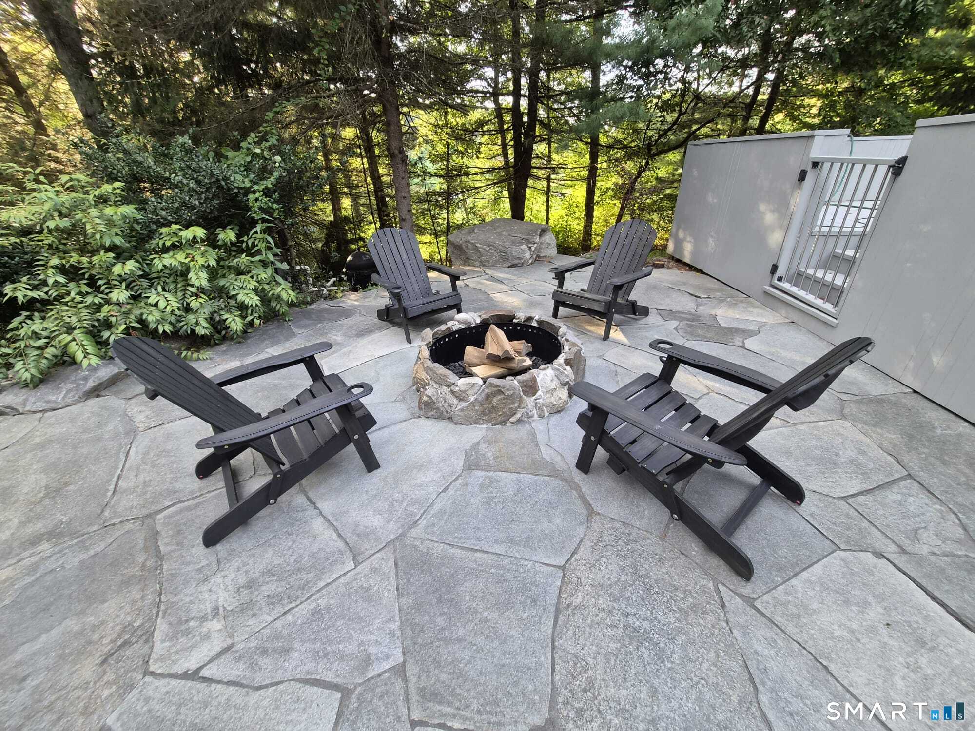 14 Codfish Lane Weston, CT 06883 - Photo 20 of 23 a view of a terrace with chairs and a fire pit
