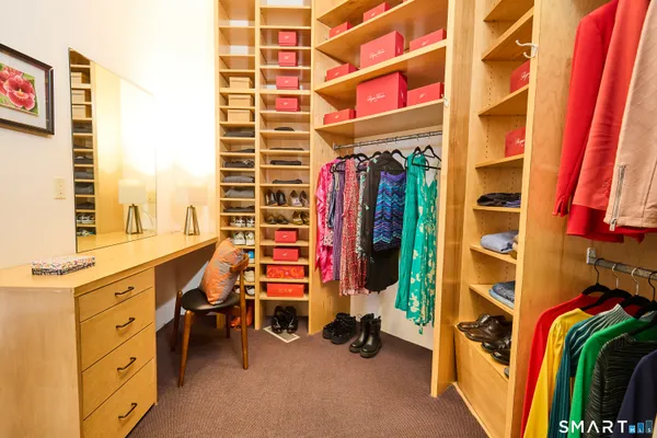 a view of walk in closet with clothes and shoes