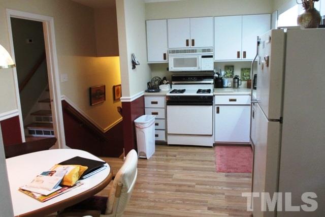 6600 King Lawrence Road Raleigh, NC 27607 - Photo 6 of 25 a kitchen with stainless steel appliances a refrigerator a stove a sink and white cabinets