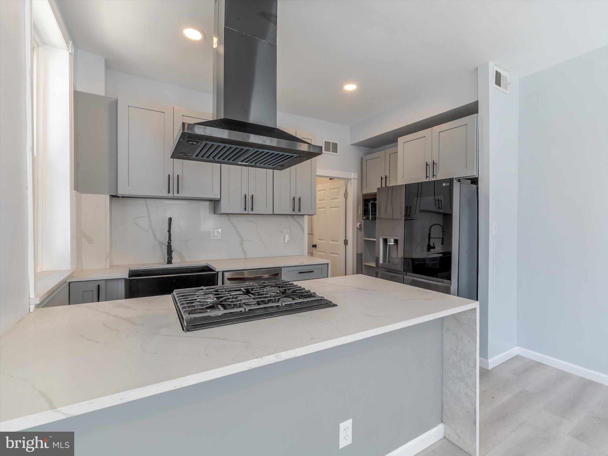 1108 Locust Street Philadelphia, PA 19107 - Photo 19 of 33 a kitchen with stainless steel appliances a refrigerator a stove a sink and white cabinets