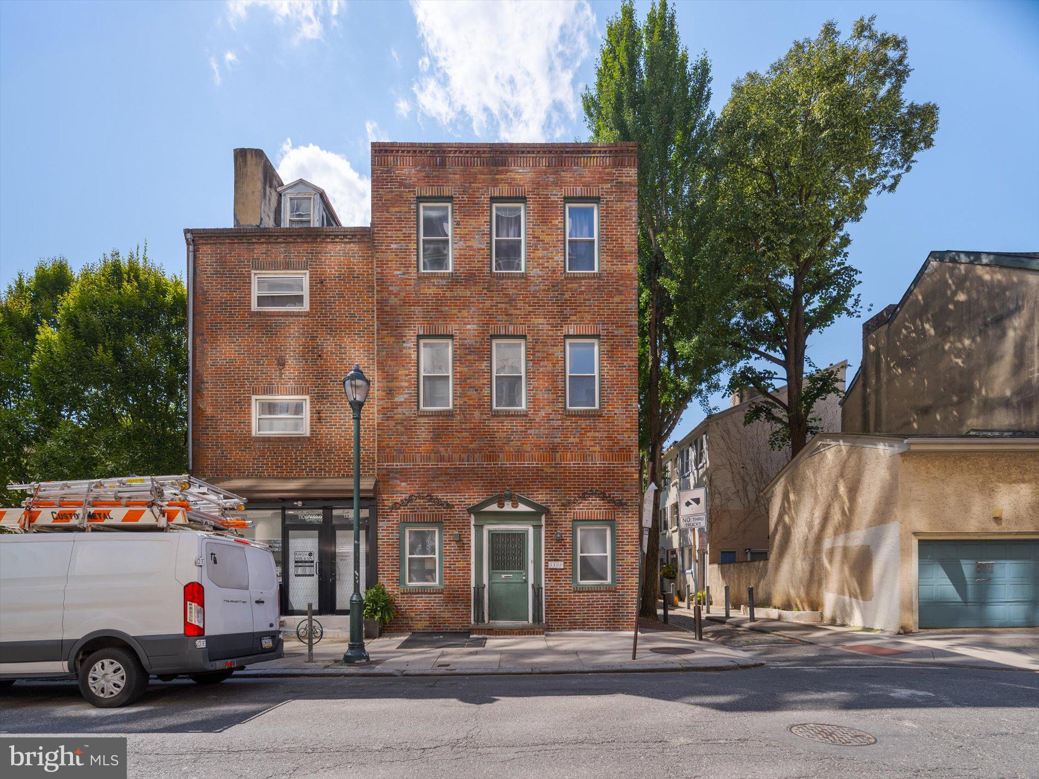1108 Locust Street Philadelphia, PA 19107 - Photo 2 of 33 a front view of a building with lot of cars and trees