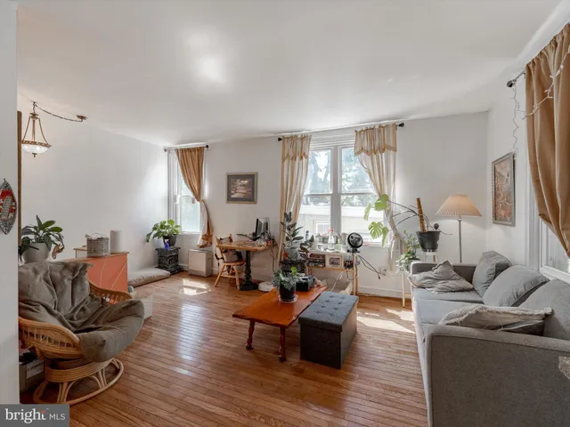 a living room with furniture fireplace and a large window