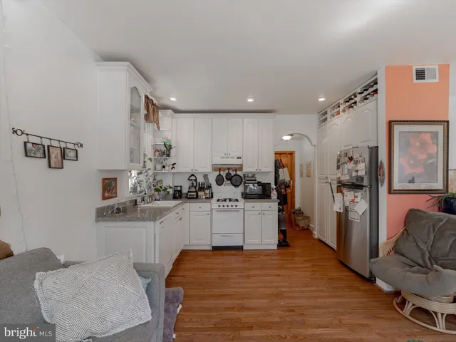 a kitchen with wooden floors and appliances
