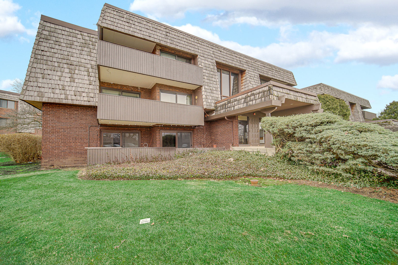 491 Timber Ridge Drive, Unit 101 Carol Stream, IL 60188 - Photo 17 of 19 a front view of a house with a garden