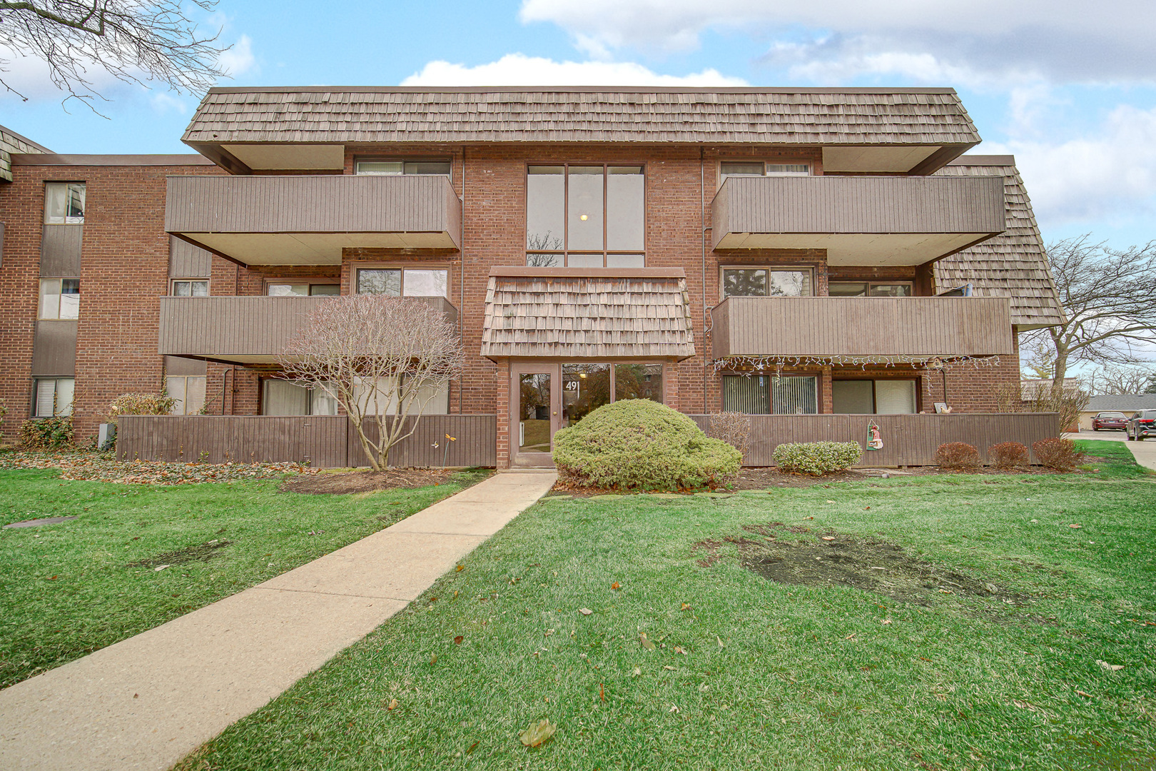491 Timber Ridge Drive, Unit 101 Carol Stream, IL 60188 - Photo 2 of 19 a view of a front of a house with a yard